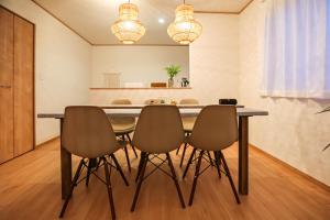 a dining room with a table and chairs at #オーシャンビューBBQ可能 #4LDK新築一軒家 #長期滞在歓迎 -- 時空間 凪 Nagi -- in Hyakuna