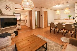 a living room with a table and chairs and a kitchen at #オーシャンビューBBQ可能 #4LDK新築一軒家 #長期滞在歓迎 -- 時空間 凪 Nagi -- in Hyakuna