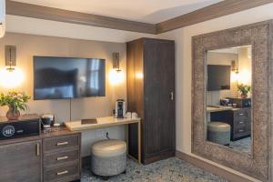 a hotel room with a desk and a large mirror at Andrew Pinckney Inn in Charleston