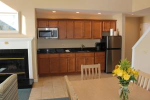 a kitchen with wooden cabinets and a table with a fireplace at Waters Edge Resort and Spa TimeShare in Westbrook