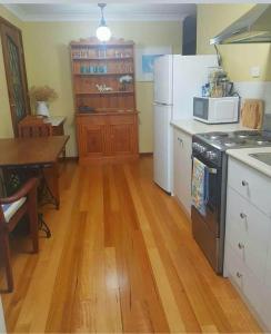 a kitchen with a stove and a refrigerator and a table at Layton Street Apartments in Esperance