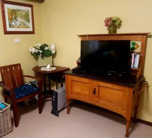 a living room with a flat screen tv on a wooden entertainment center at Layton Street Apartments in Esperance