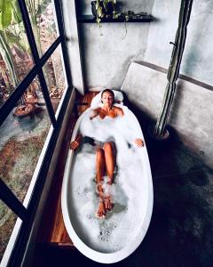 a man is laying in a bath tub at OCEANNA - Uluwatu, Bali in Uluwatu