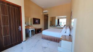 Schlafzimmer mit einem Bett, einem Schreibtisch und einer Tür in der Unterkunft Cahaya Villa Garut in Garut