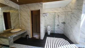 a bathroom with a tub, toilet and sink at Cahaya Villa Garut in Garut