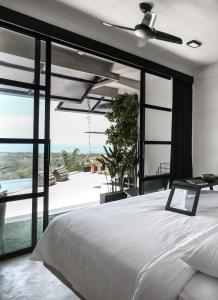 a bedroom with a bed and a view of the ocean at OCEANNA - Uluwatu, Bali in Uluwatu