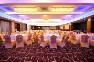un gran salón de banquetes con mesas y sillas blancas en Kethumathee Hotel & Banquet, en Ratnapura