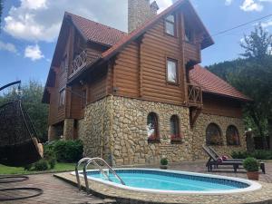 una casa con piscina frente a una casa en Villa Bilogirya en Yaremche