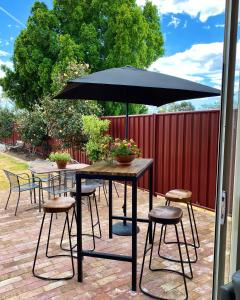 a table and chairs with an umbrella on a patio at The Coorow Hotel in Coorow