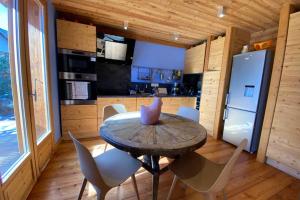 una cucina con tavolo e sedie in una stanza di le Serre Barbin : Chalet ensoleillé, tout confort a Le Monêtier-les-Bains