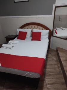 um quarto com uma cama grande e almofadas vermelhas em Hotel Montreal em São Paulo