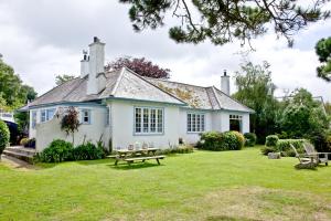 een wit huis met een picknicktafel in de tuin bij Cregoes, Mylor in Flushing