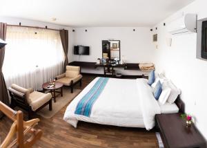 a bedroom with a bed and a living room at Dhulikhel Mountain Resort in Dhulikhel