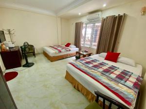 a hotel room with two beds and a window at Viet Nhat Halong Hotel - Bai Chay in Ha Long