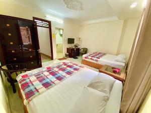 a hotel room with two beds and a mirror at Viet Nhat Halong Hotel - Bai Chay in Ha Long