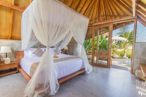 a bedroom with a bed with mosquito netting at Lasamana Villas Ubud by Pramana Villas in Ubud