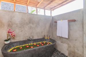 a bath tub filled with flowers in a bathroom at Lasamana Villas Ubud by Pramana Villas in Ubud