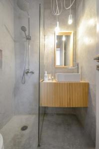 a bathroom with a sink and a mirror and a shower at Ydreos Studios & Apartments in Mikri Vigla