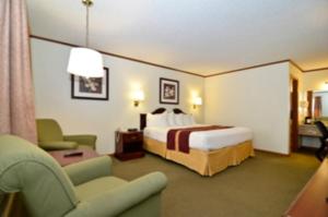 a hotel room with a bed and a chair at SureStay by Best Western Cameron in Cameron