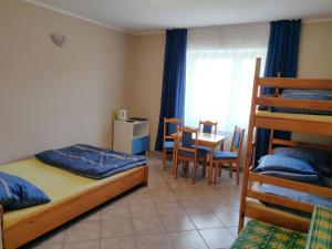a bedroom with a bunk bed and a table and chairs at Willa Zacisze Sianożęty in Sianozety