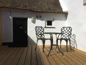 a table and two chairs in front of a house at Bakers Cottage Ludham - Norfolk Broads in Ludham