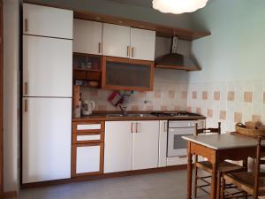 a kitchen with white cabinets and a table in it at Villa Raniero Gatti in San Michele in Teverina