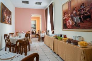 a restaurant with tables and chairs and a painting on the wall at Tsentralnaya Hotel in Odesa
