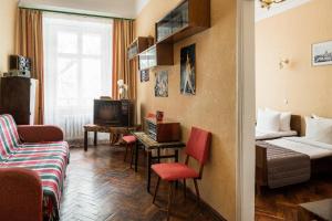 a living room with a couch and a bed and a tv at Tsentralnaya Hotel in Odesa
