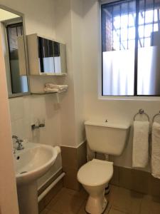 baño con aseo y lavabo y ventana en Hotel 59 Sydney en Sídney