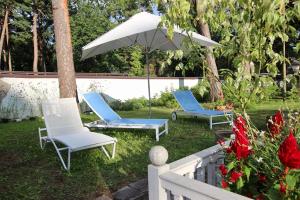 two chairs and an umbrella in a yard at Smiling house & Baltic beach in Jūrmala