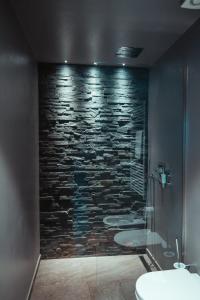a bathroom with three sinks and a stone wall at Maison Bionaz Ski & Sport in Aosta