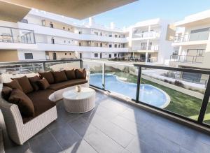 an apartment balcony with a couch and a pool at Family apartments Albur Village II in Alvor