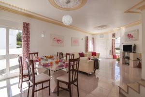 a dining room and living room with a table and chairs at Villa Santo Estevão in Olhos de Água