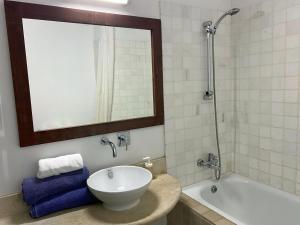 a bathroom with a sink and a tub and a mirror at Eveleos Country House in Tochni