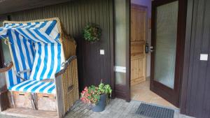 a wicker chair sitting on a porch next to a door at Appartement Lotte in Kiel