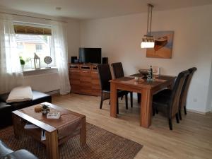 a living room with a table and chairs and a dining room at Ferienwohnung Am Lindenkrog in Rickert
