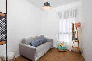 sala de estar con sofá gris y ventana en Penthouse Sunset Balcony by Sea N' Rent, en Nahariyya 24 fotos más