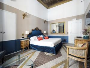 sypialnia z łóżkiem, biurkiem i lustrem w obiekcie Nobildonne Relais w Rzymie