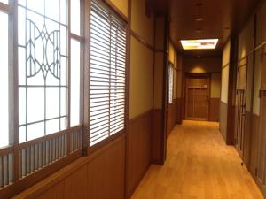 an empty hallway with large windows and a hallway at Roman Kan in Kyoto