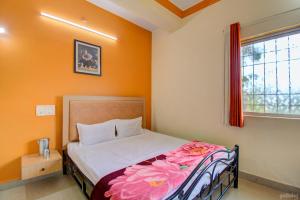 Un dormitorio con una cama con una manta de flores. en Shilpa Strawberry Garden, en Mahabaleshwar