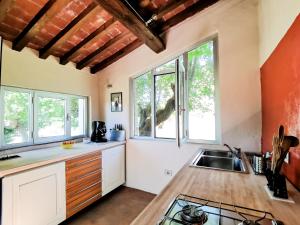 a kitchen with a sink and some windows at La Bacaia in Marciano Della Chiana