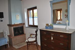 a room with a dresser and a mirror and a chair at Azienda Agricola Biologica La Cardellina in Tolfa +65 photos