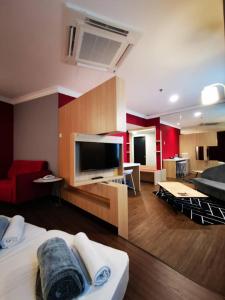 a living room with a large television and a couch at Regalodge Hotel Ipoh in Ipoh