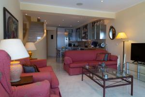 a living room with pink couches and a table at Villa Noria in Aghia Marina