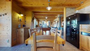 uma sala de jantar com uma mesa longa num camarote em REFLET DES AIGUILLES - Chalet avec Jacuzzi em La Toussuire