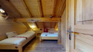 a room with two beds in a wooden cabin at REFLET DES AIGUILLES - Chalet avec Jacuzzi in La Toussuire