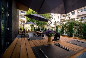 een houten terras met tafels en parasols op een gebouw bij Bulvar Hotel in Gorzów Wielkopolski