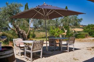 a table and chairs under a large umbrella at Azienda Agrituristica Le Chiuse in Manciano
