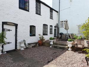 a white building with a porch and a patio at Old Printers Ruthin in Ruthin