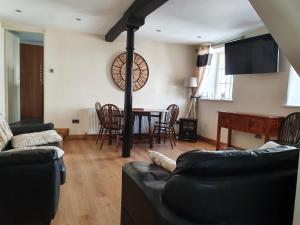 a living room with a couch and a table with chairs at Old Printers Ruthin in Ruthin